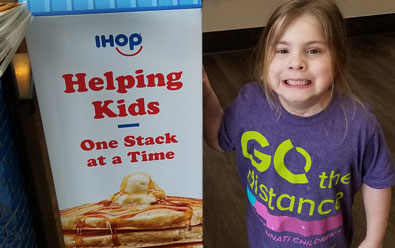Child with IHOP pancake sign.